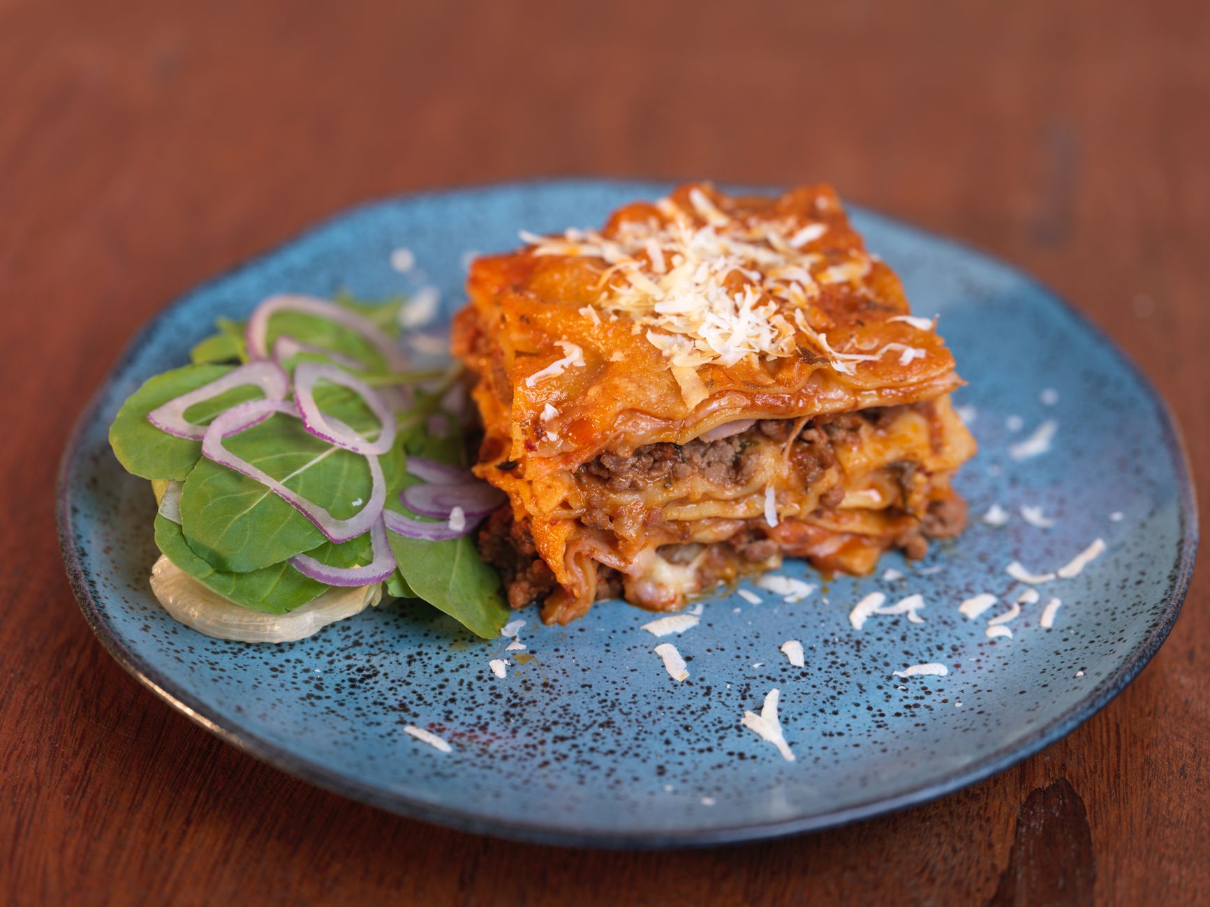 Dutch oven with cooked beef enchiladas topped with melted cheese and garnished with cilantro