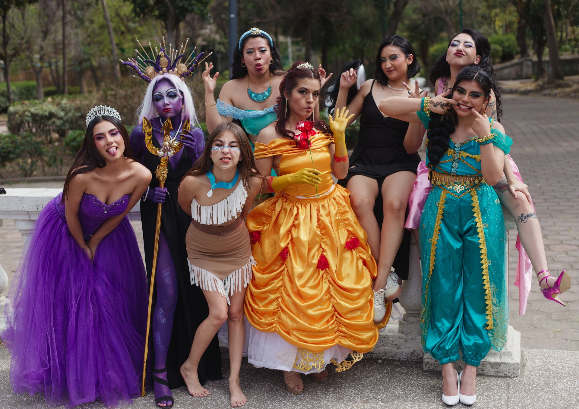 A joyful group of women dressed as Disney characters posing playfully outdoors.