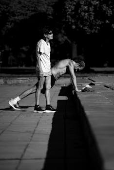 A black and white photograph of two people exercising outdoors in Buenos Aires.