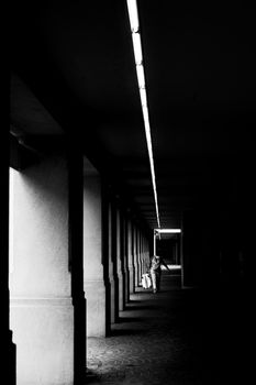 Monochrome photograph capturing a solitary figure in a shadowy alleyway in Buenos Aires, Argentina.