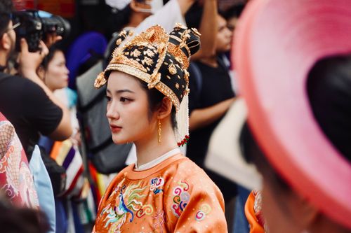Free Vibrant parade showcasing traditional Asian attire featuring a detailed headdress and embroidered clothing. Stock Photo