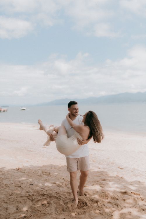 Free A happy couple in love enjoying a sunny day on a sandy beach. Stock Photo