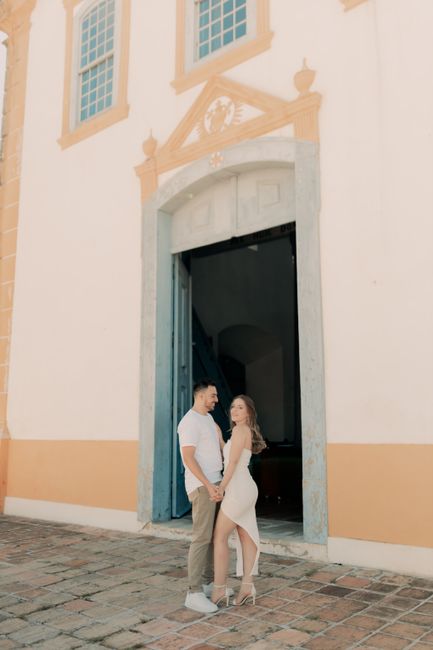 Couple in love standing near an elegant historic building entrance, romantic moment.