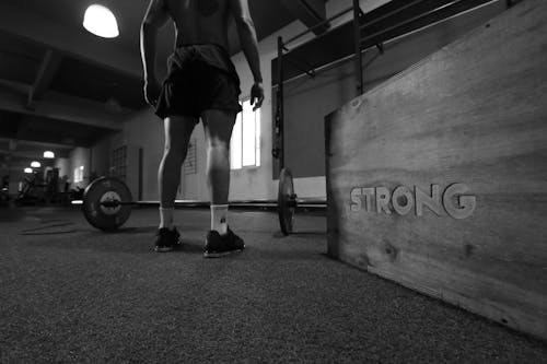 Free Grayscale Photo Of Man Standing Beside Barbell Stock Photo