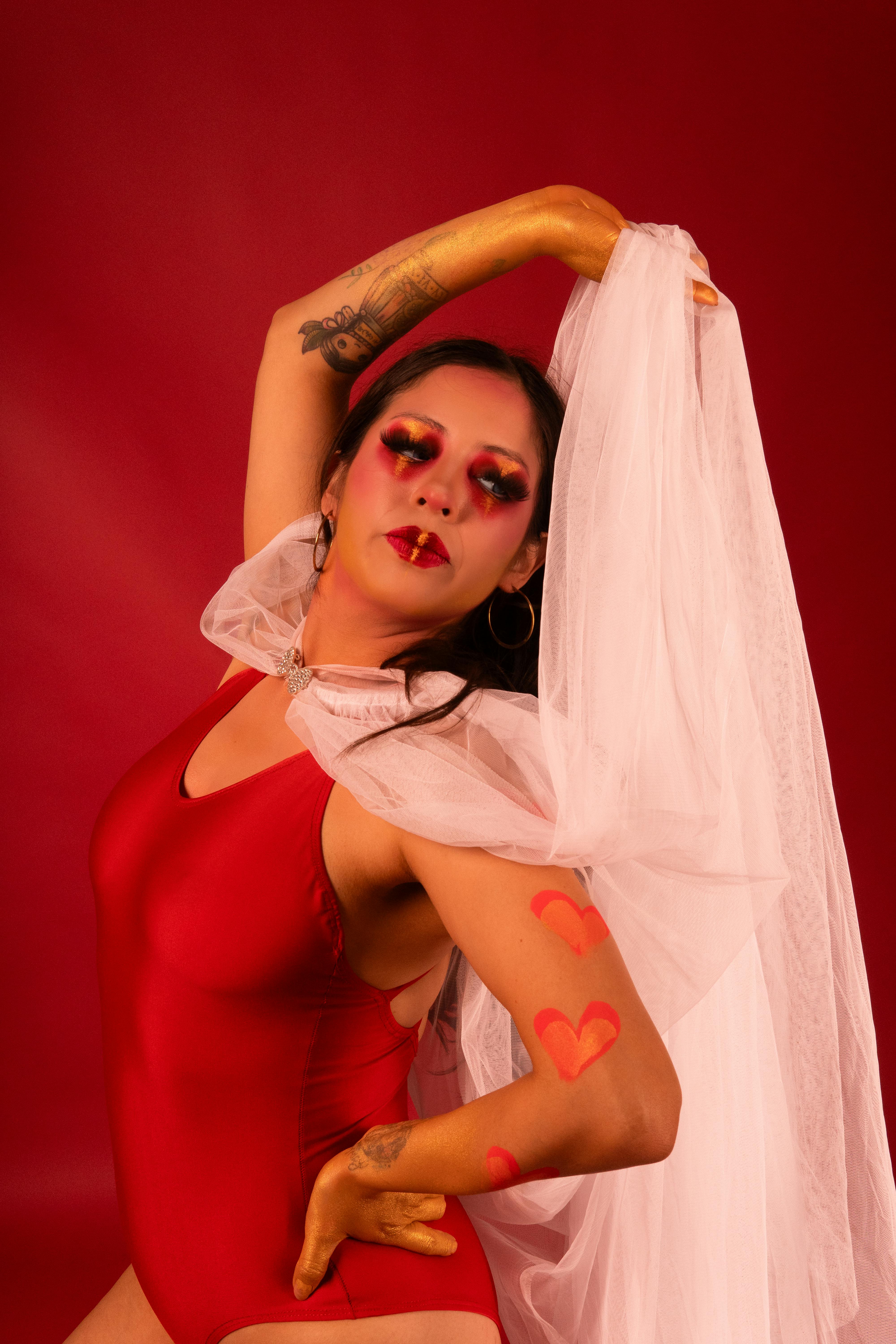 Ücretsiz Yaratıcı makyajı ve canlı kırmızı kıyafetiyle tutkuyu ifade eden Latina dansçının büyüleyici portresi. Stok Fotoğraflar