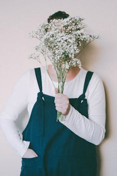 室内，一个穿着工作服的人拿着一束婴儿呼吸花