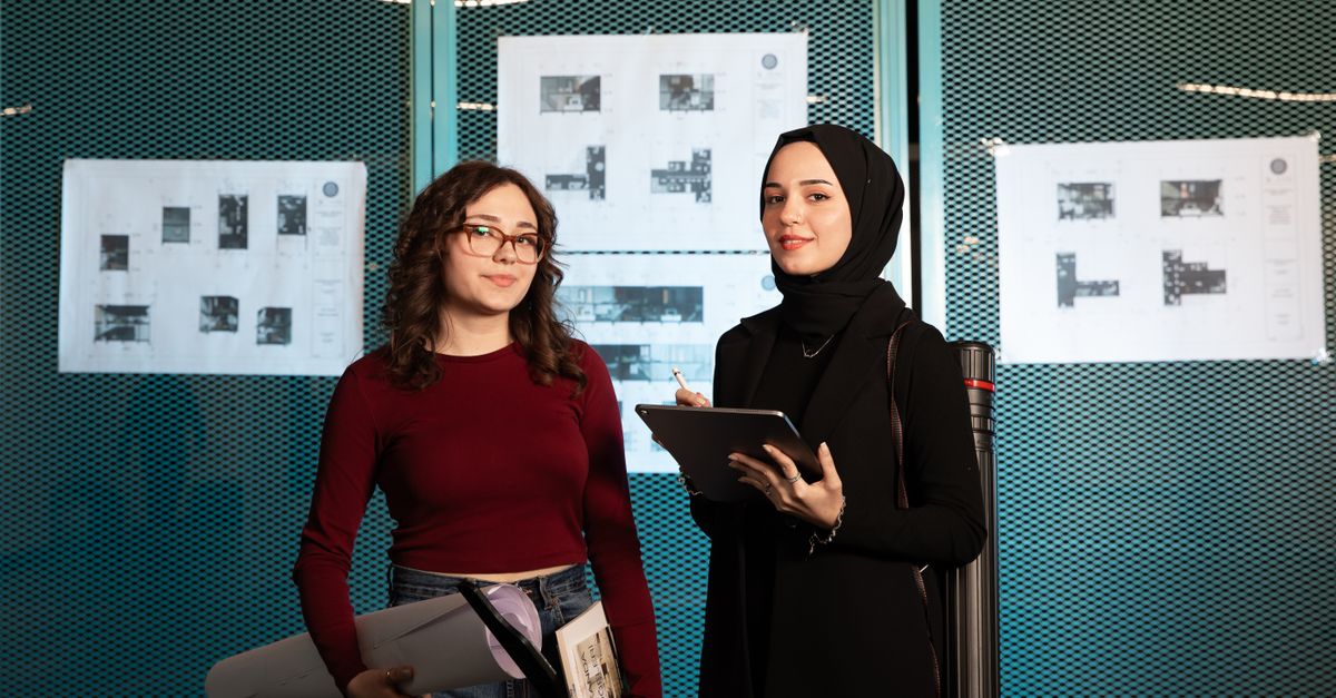 young professionals reviewing a tablet with green energy graphics in a modern office