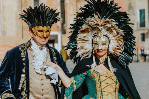 Free Couple in elaborate feathered masks and costumes at the Venetian Carnival. Stock Photo