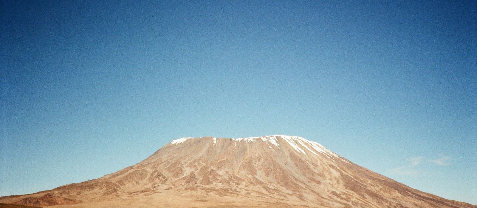 Stunning capture of Mount Kilimanjaro with its snowy peak against a clear blue sky in Tanzania. — flights from Dar Es Salaam to Kilimanjaro