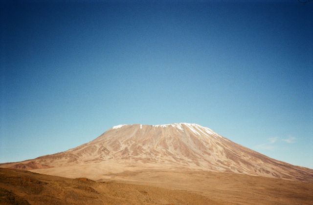 Stunning capture of Mount Kilimanjaro with its snowy peak against a clear blue sky in Tanzania. — arriving in Arusha