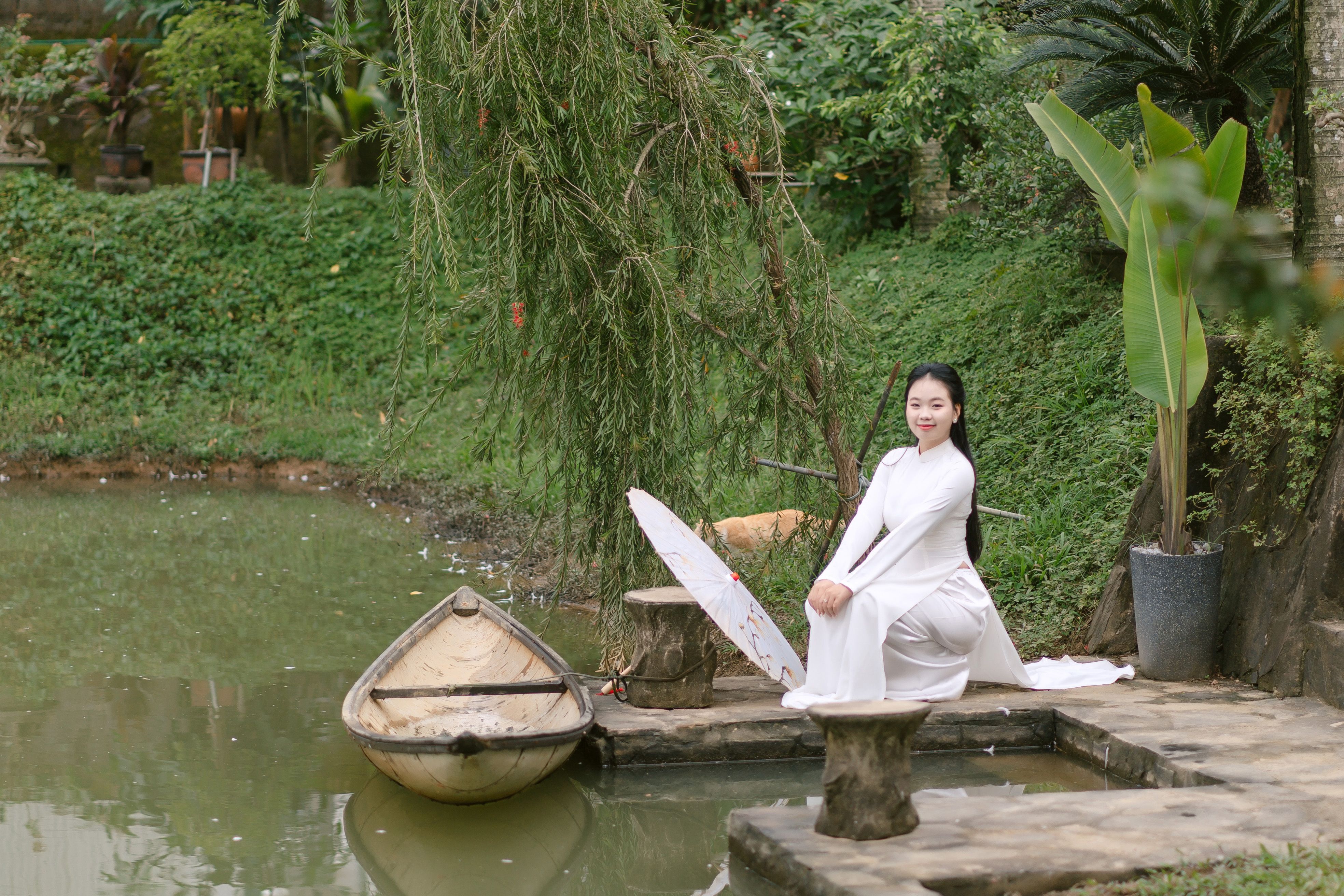 Graceful Woman in Traditional Dress by a Pond · Free Stock Photo