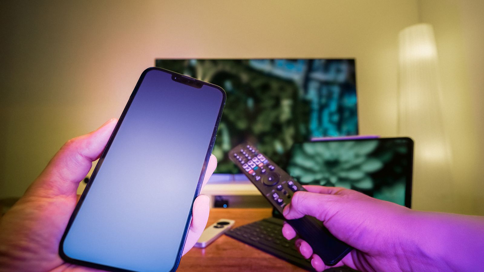 Smartphone and remote control used with television equipment in a modern home