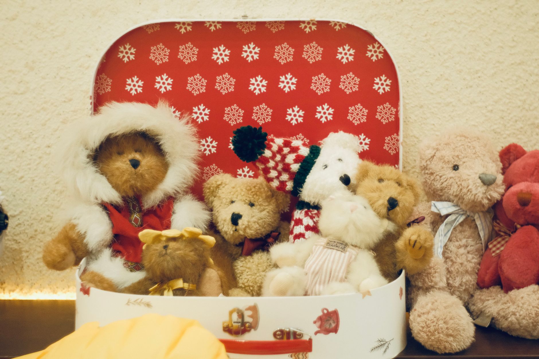 A charming collection of teddy bears in a red festive box, perfect for holiday decorations.
