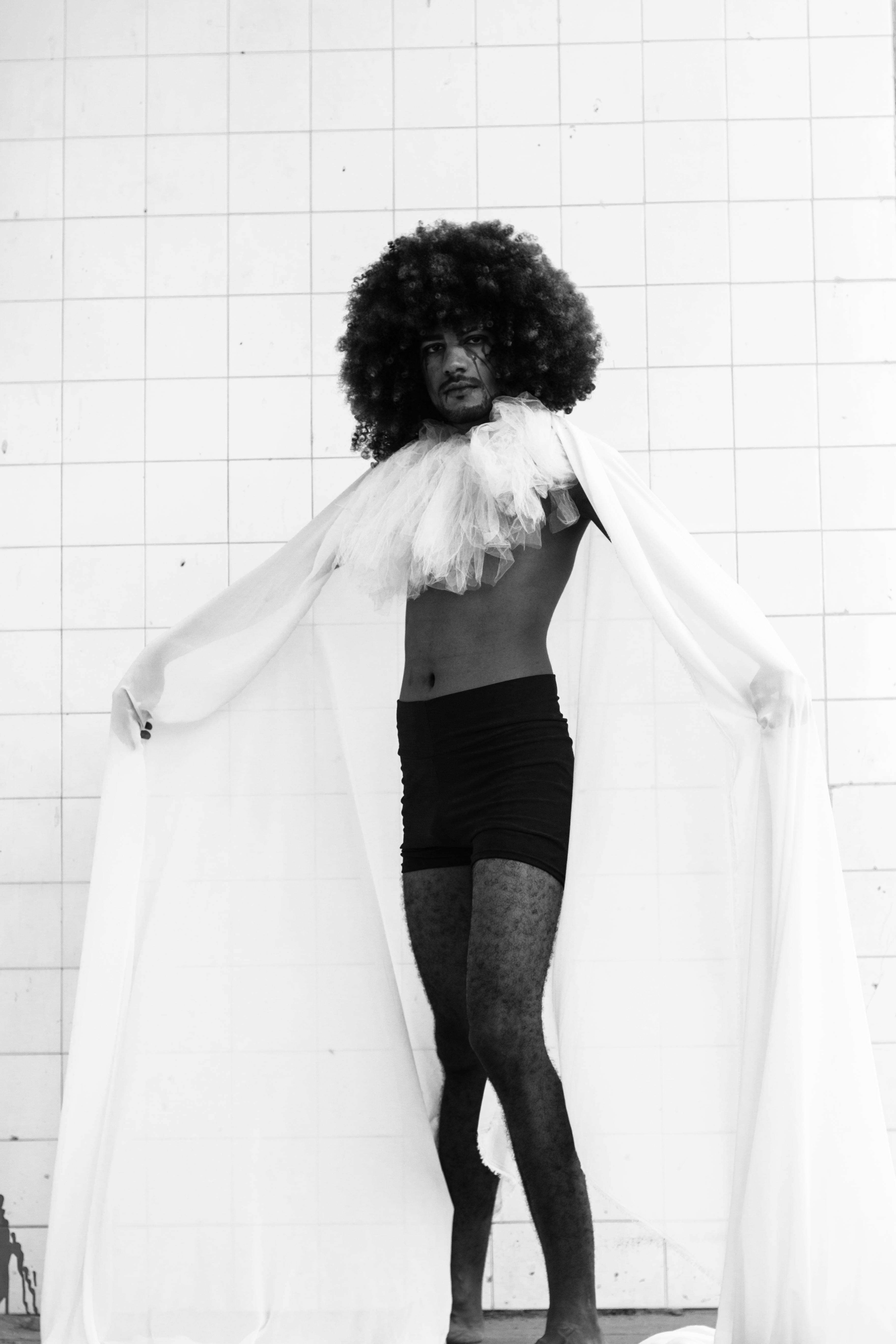 Striking black and white image of a male model in avant-garde fashion.
