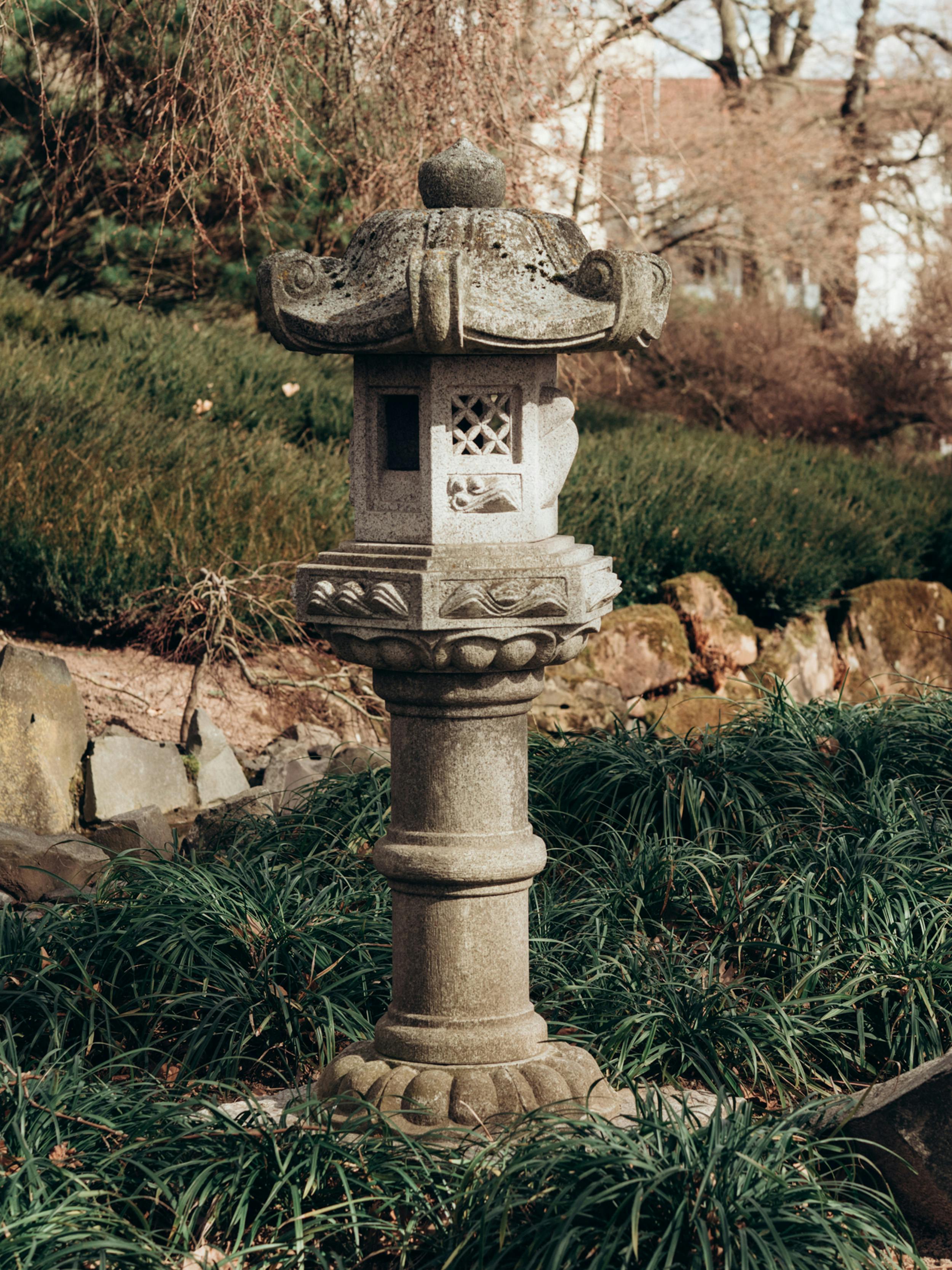 Elegant stone lantern in a serene Japanese garden landscape.