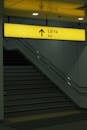 Yellow Exit Sign Above Staircase Indoors