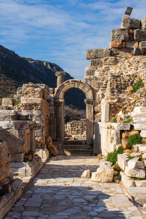Free Explore the ancient stone ruins of Ephesus, featuring a prominent stone archway and rich historical architecture. Stock Photo