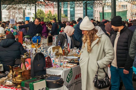 Busy outdoor bazaar with diverse vendors and shoppers exploring antique and modern items.