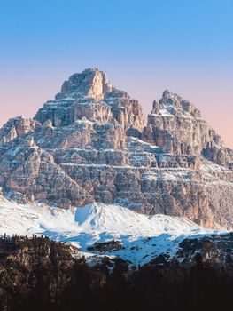 Snow-covered peaks of the Dolomites in Veneto, Italy, glowing under a serene sunset.