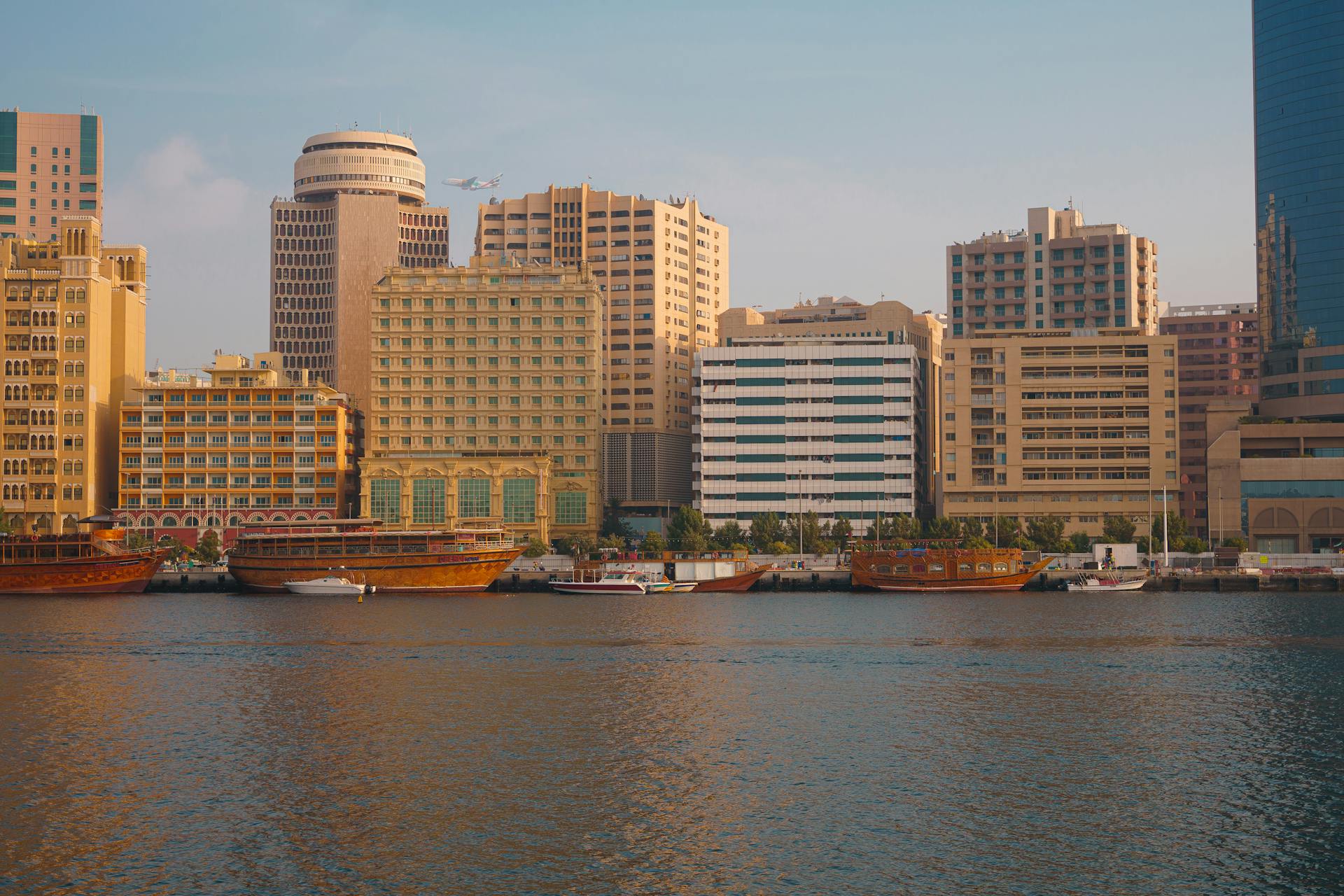 A picturesque view of Dubai Creek with traditional boats and modern city skyline.