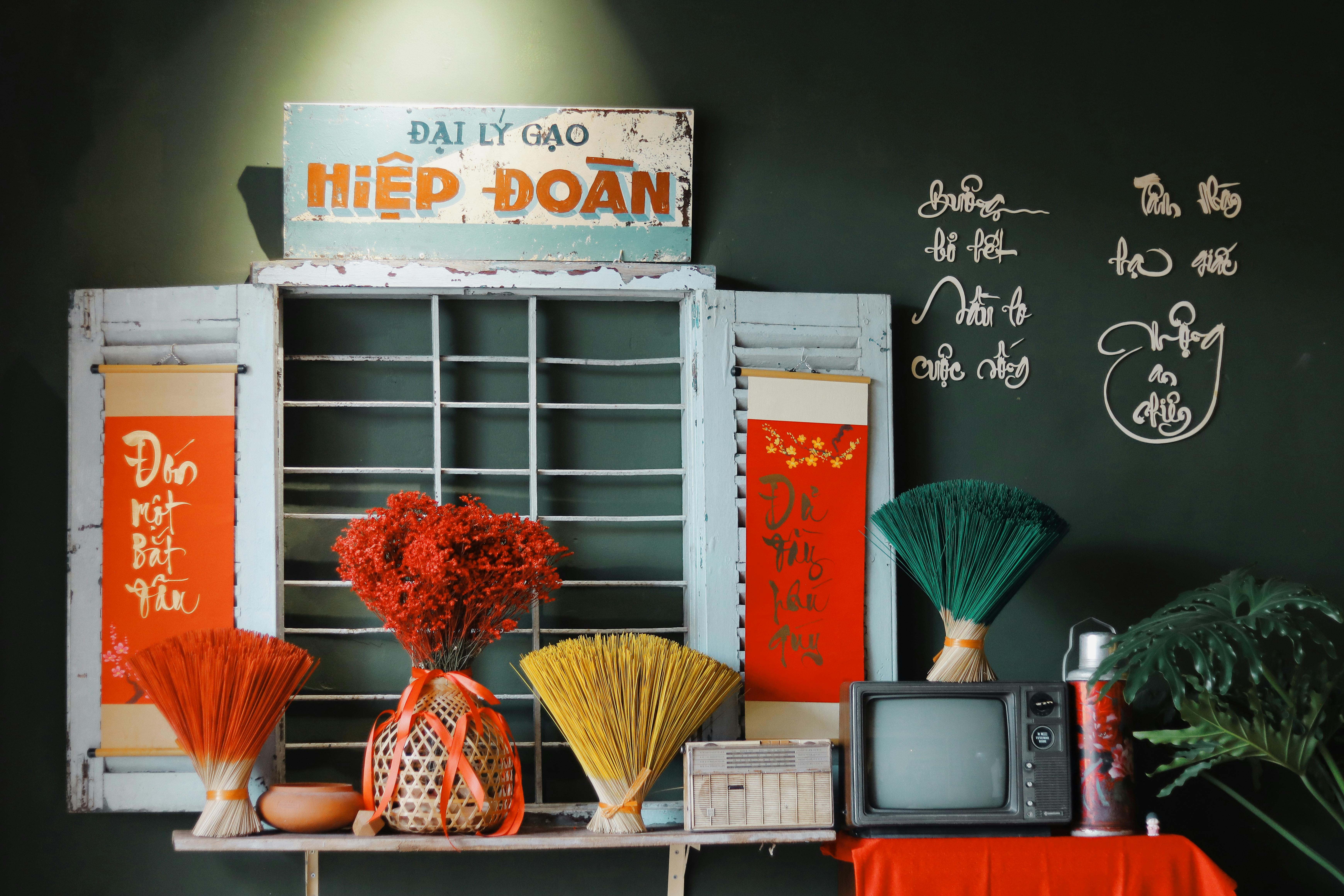 Colorful Vietnamese interior with vintage elements, featuring an old TV, flowers, and traditional decor.
