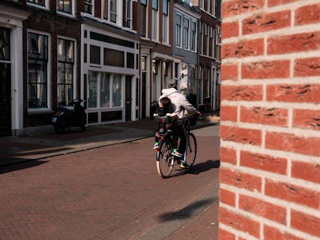 A view of a father and child cycling through a quaint street in Haarlem, Netherlands.