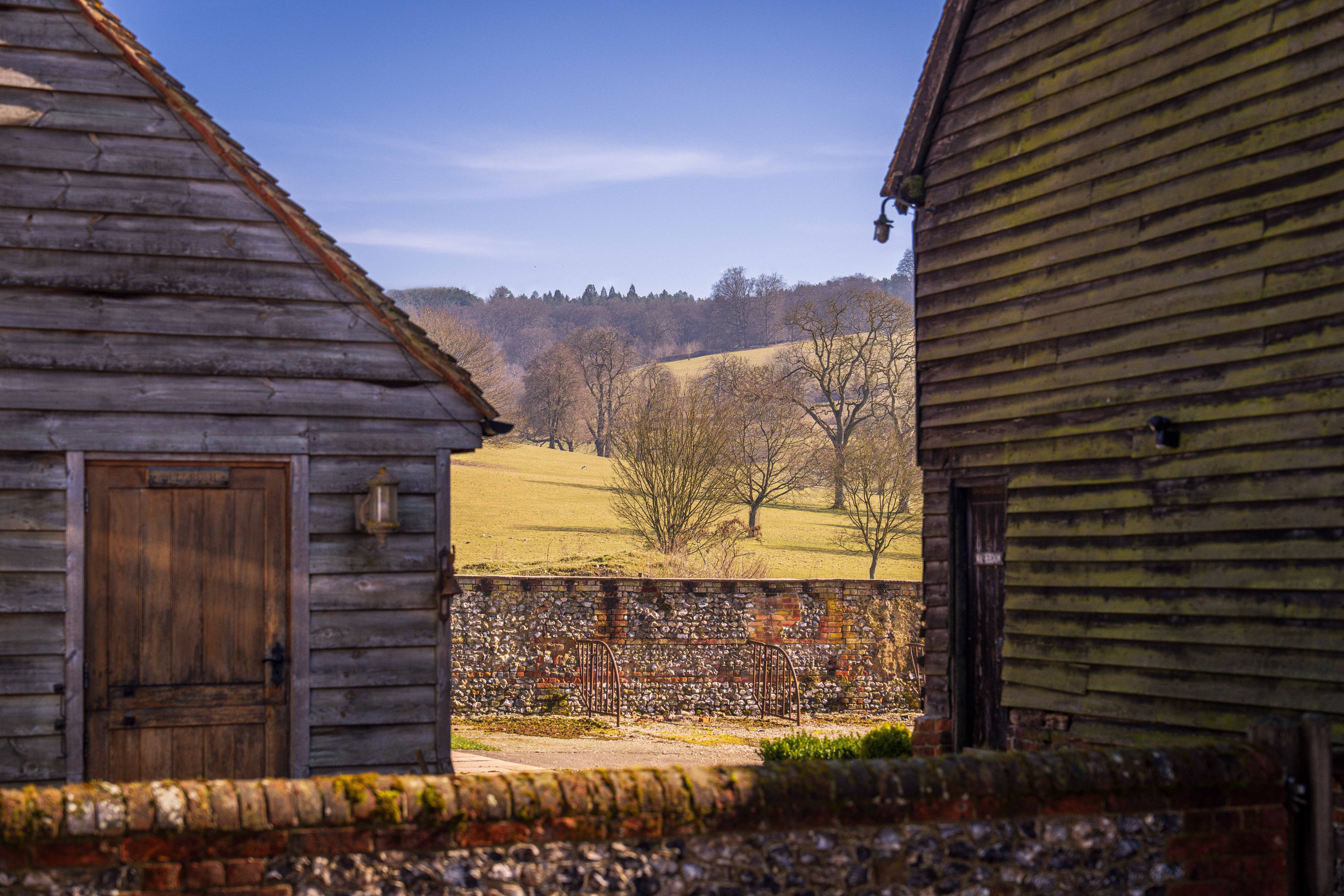 Rustic Countryside Landscape with Wooden Barns · Free Stock Photo