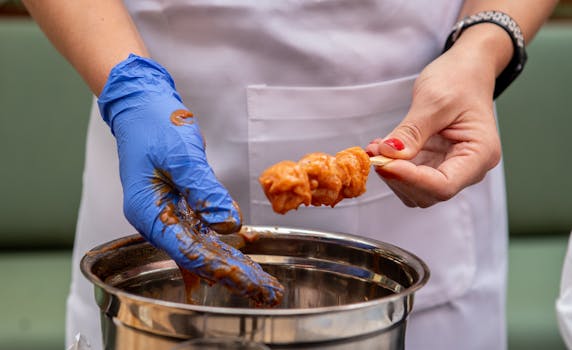 Hands marinating and preparing chicken skewers, showcasing culinary preparation.