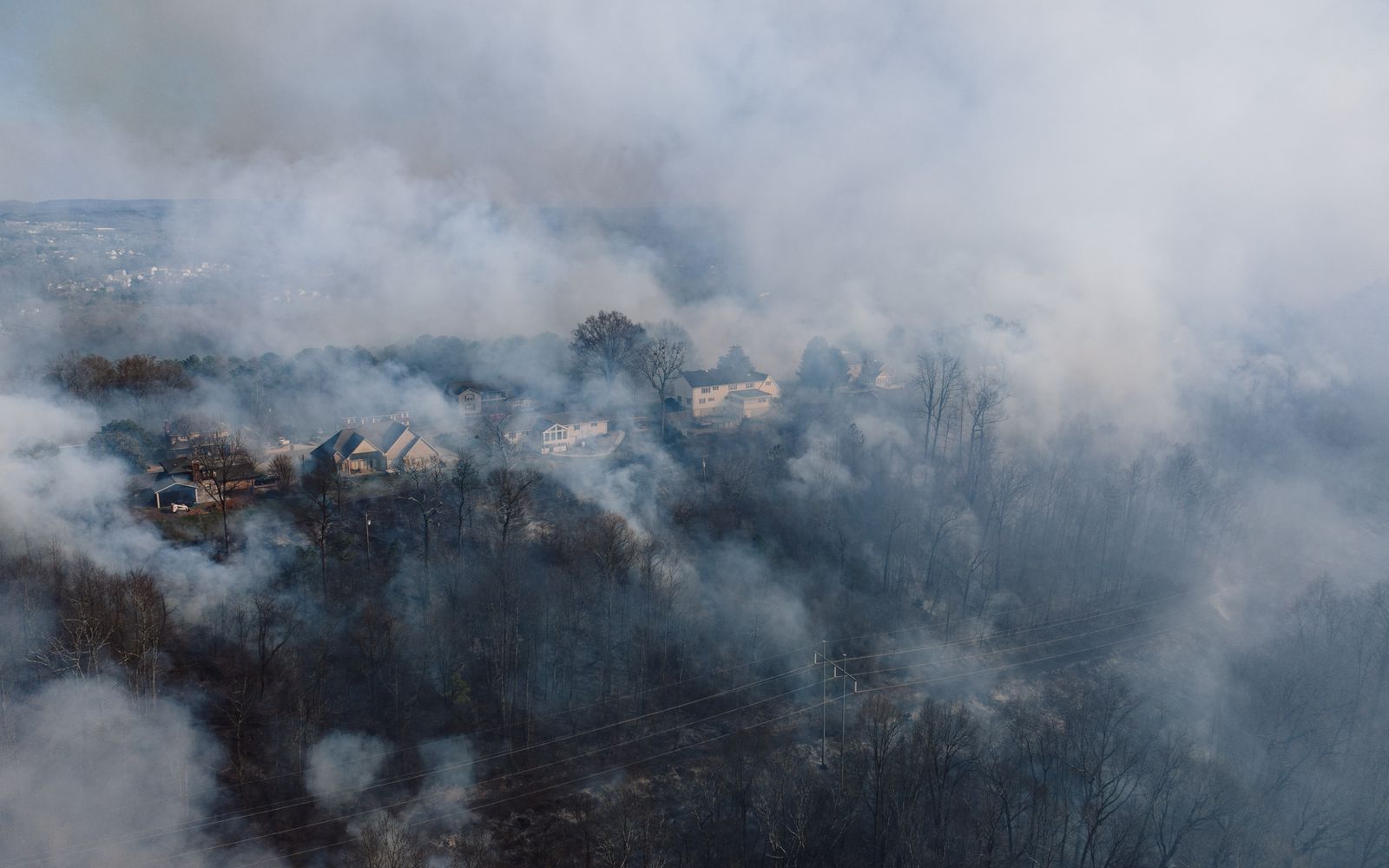 An aerial view of smoke from a forest fire drifting over wooded neighborhoods near Rossville, Georgia.