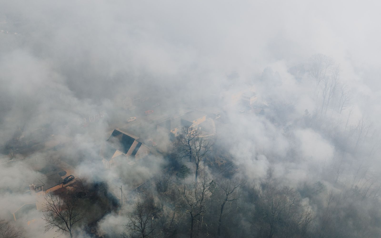 Aerial view of a residential neighborhood partly hidden under a layer of wildfire smoke