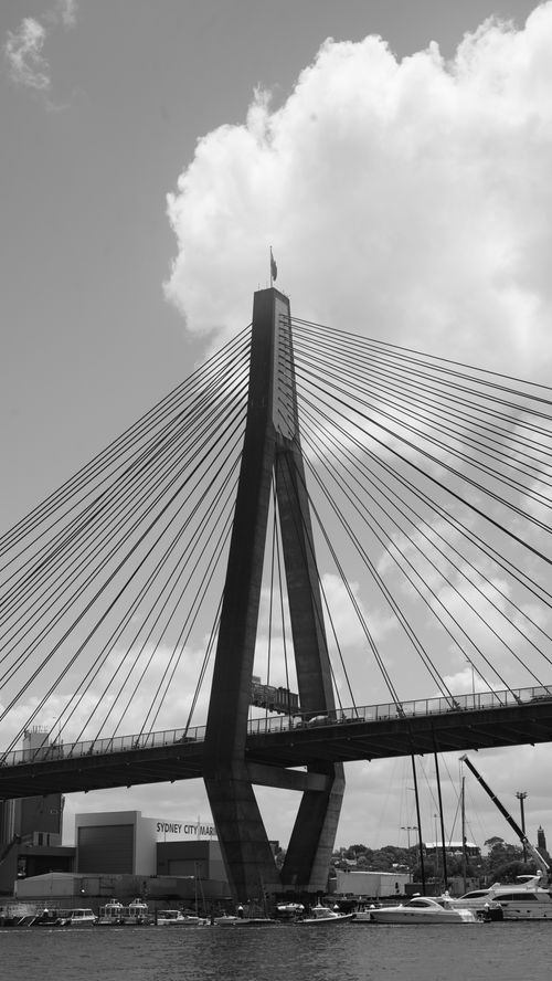 Free Black and white photo of Anzac Bridge with a dramatic sky and boats below. Stock Photo