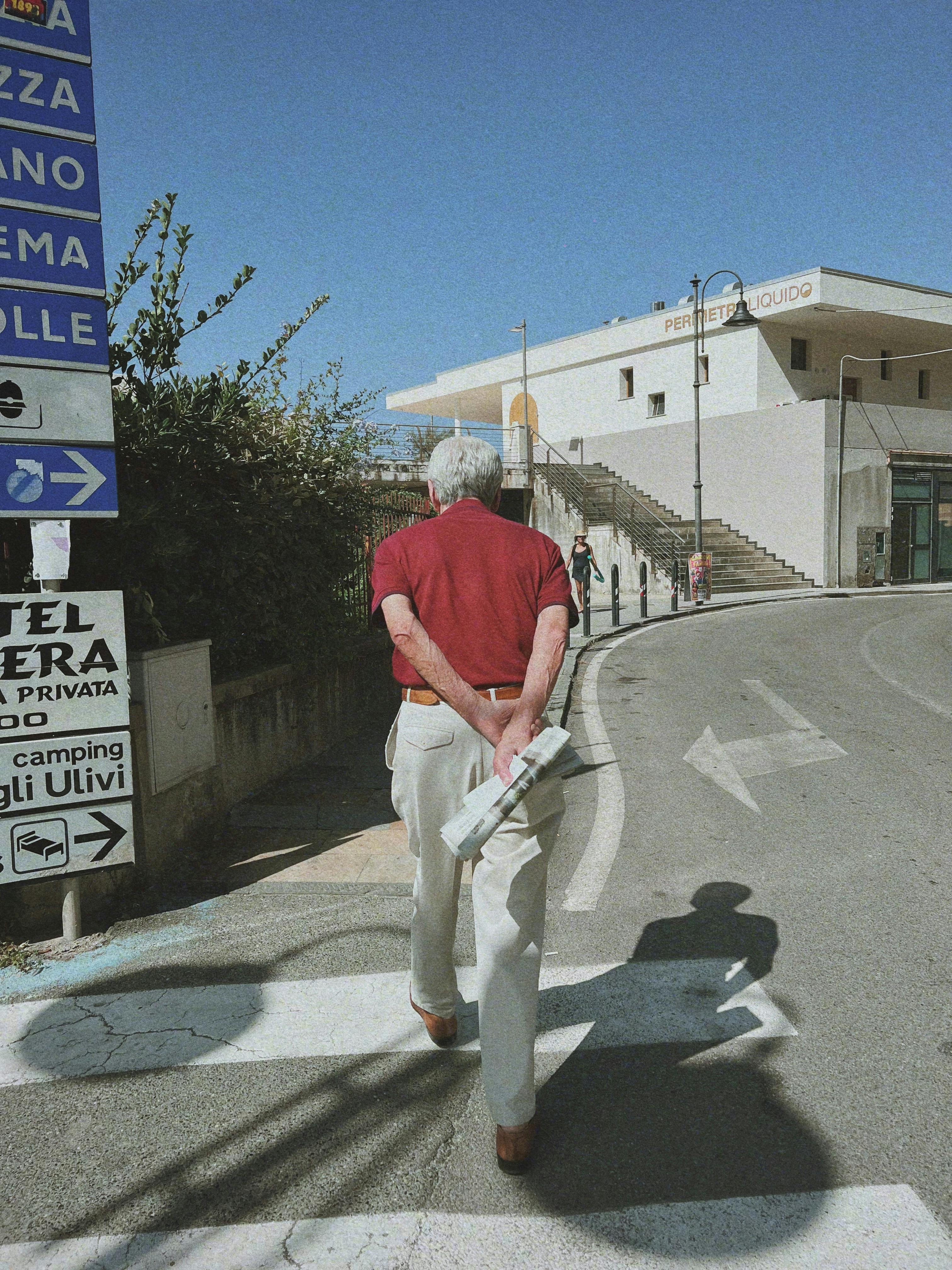 An elderly man strolling through Deiva Marina in sunny Liguria, Italy.