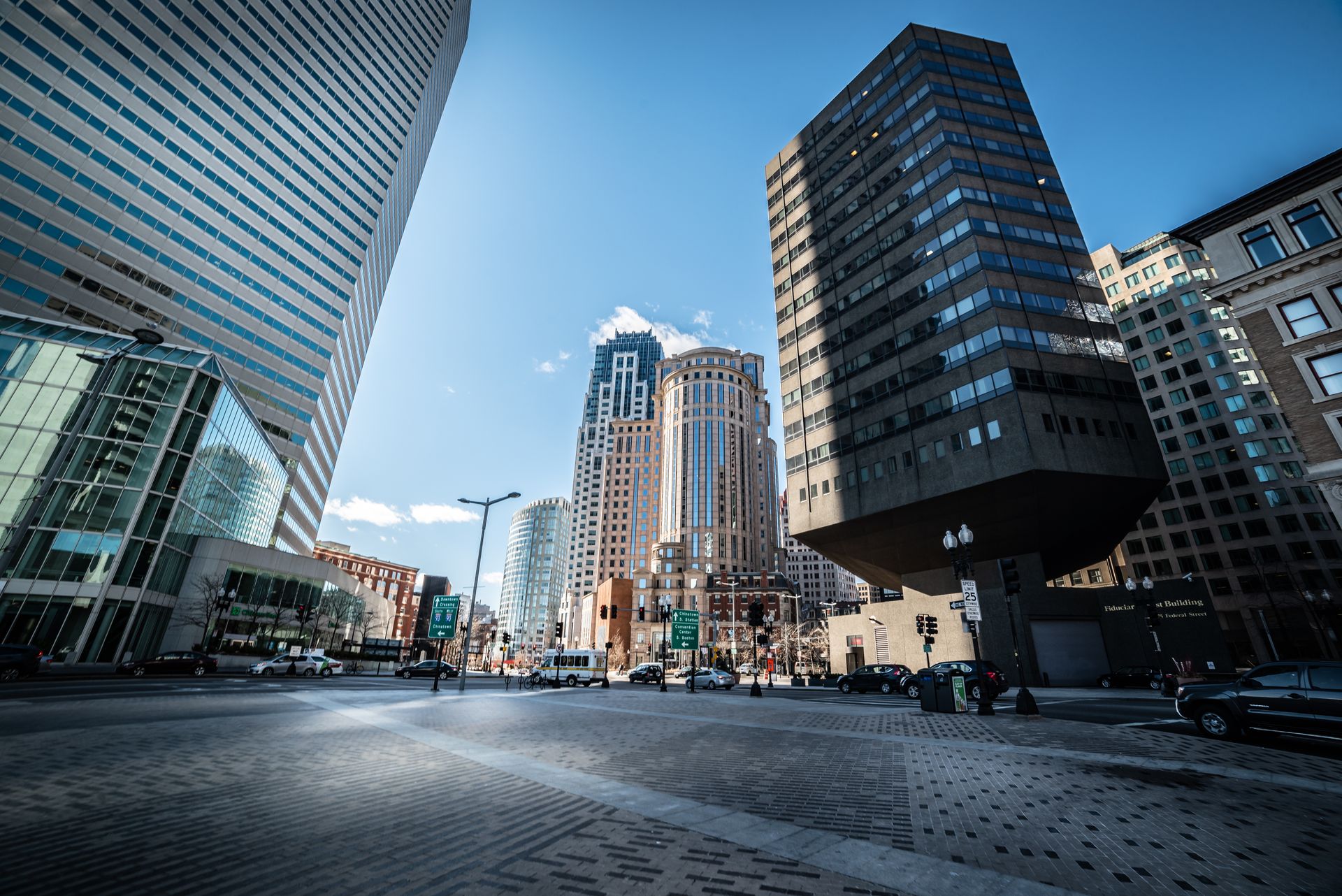 Bright daylit view of Boston Financial District with modern glass and historic buildings under clear blue sky
