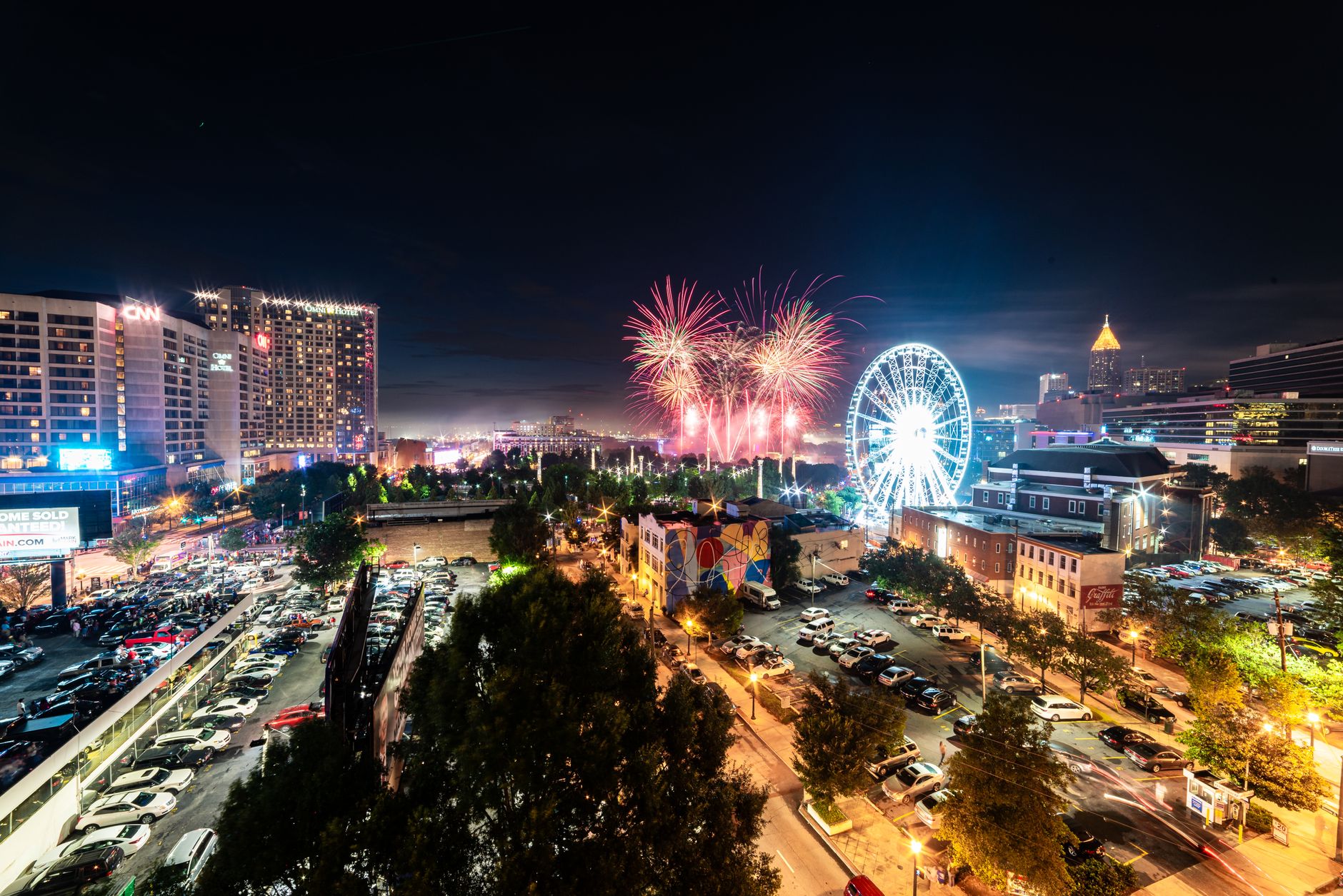 A vibrant display of fireworks illuminates the Atlanta skyline, featuring notable landmarks.