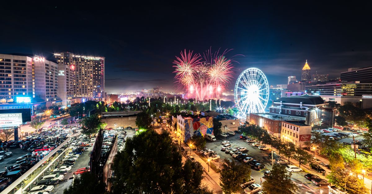 A vibrant display of fireworks illuminates the Atlanta skyline, featuring notable landmarks.