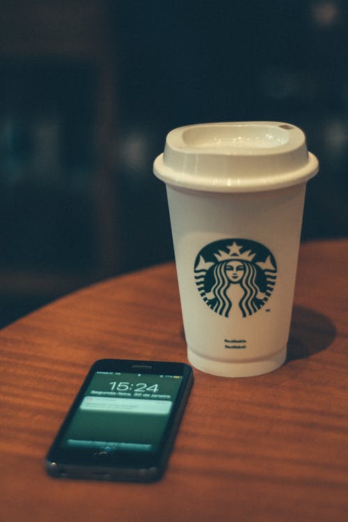 Free Starbucks Disposable Cup Beside Iphone 5s Stock Photo