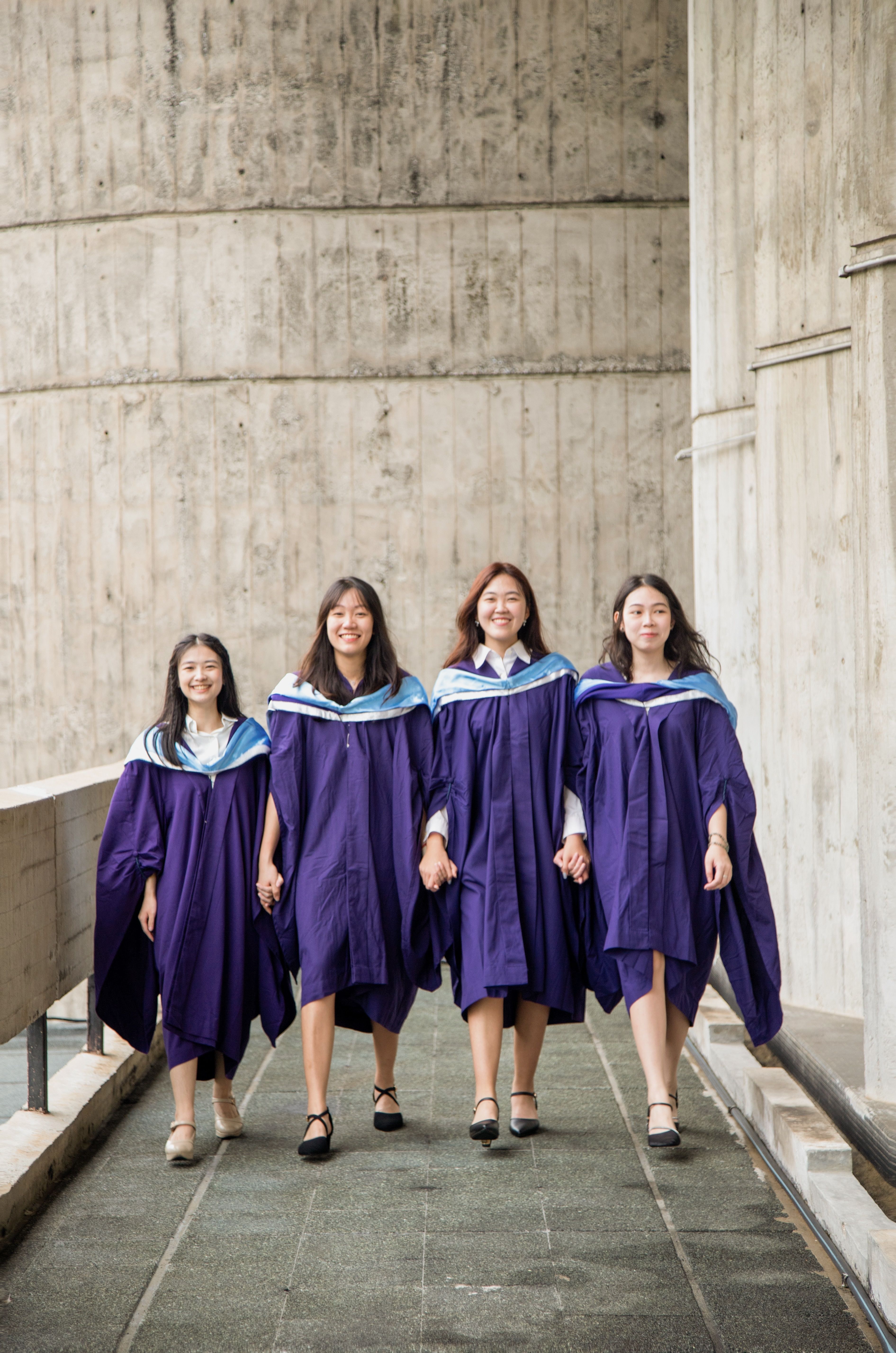 Group of Graduates Celebrating in Gowns · Free Stock Photo