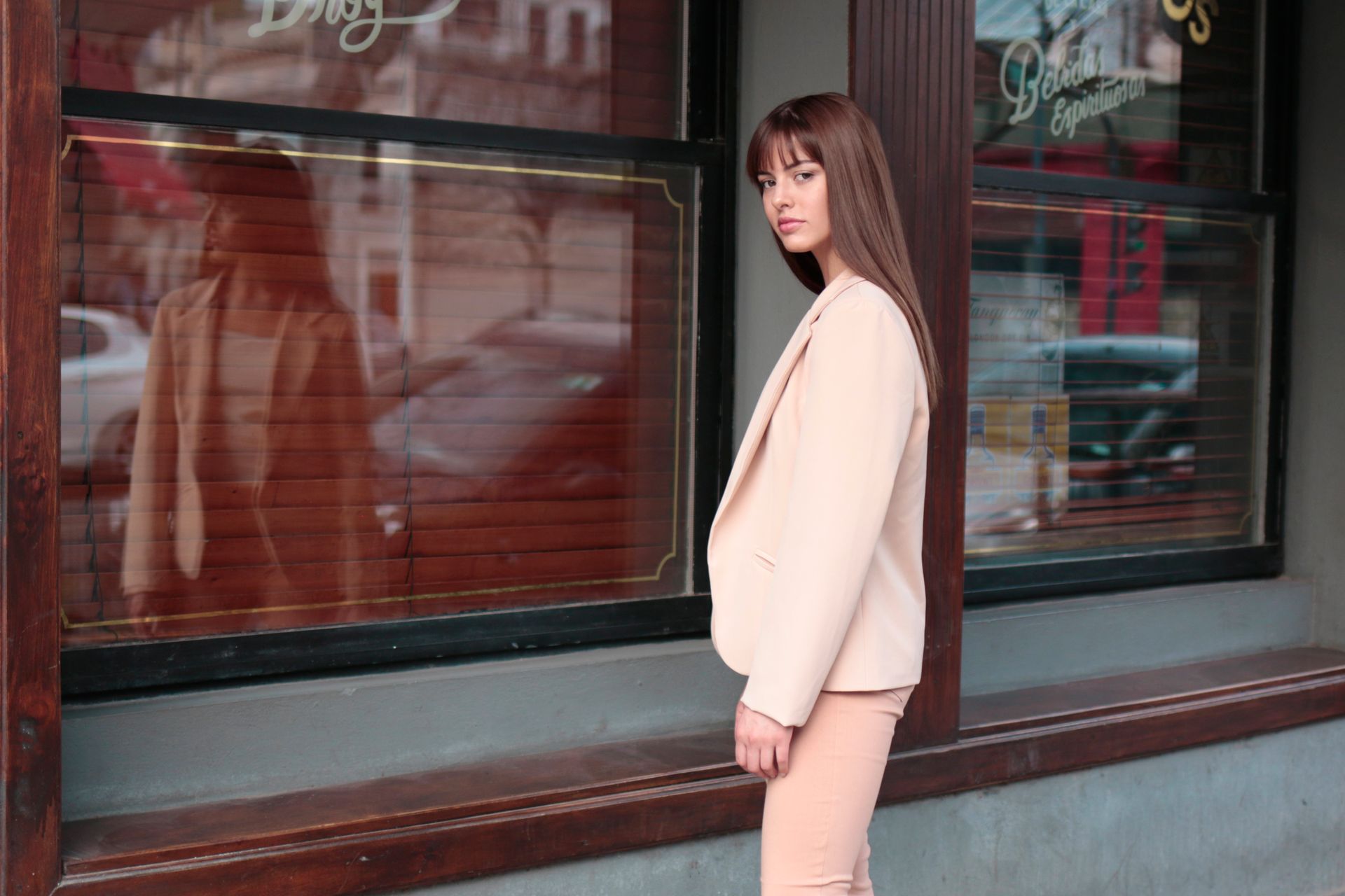 Stylish model posing in front of a street store window in Buenos Aires.