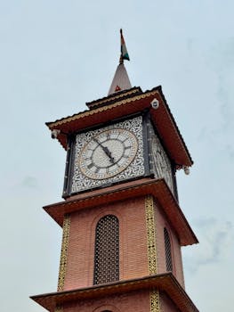 Close-up of an intricate clock tower with a flag, highlighting architectural beauty on a clear day.