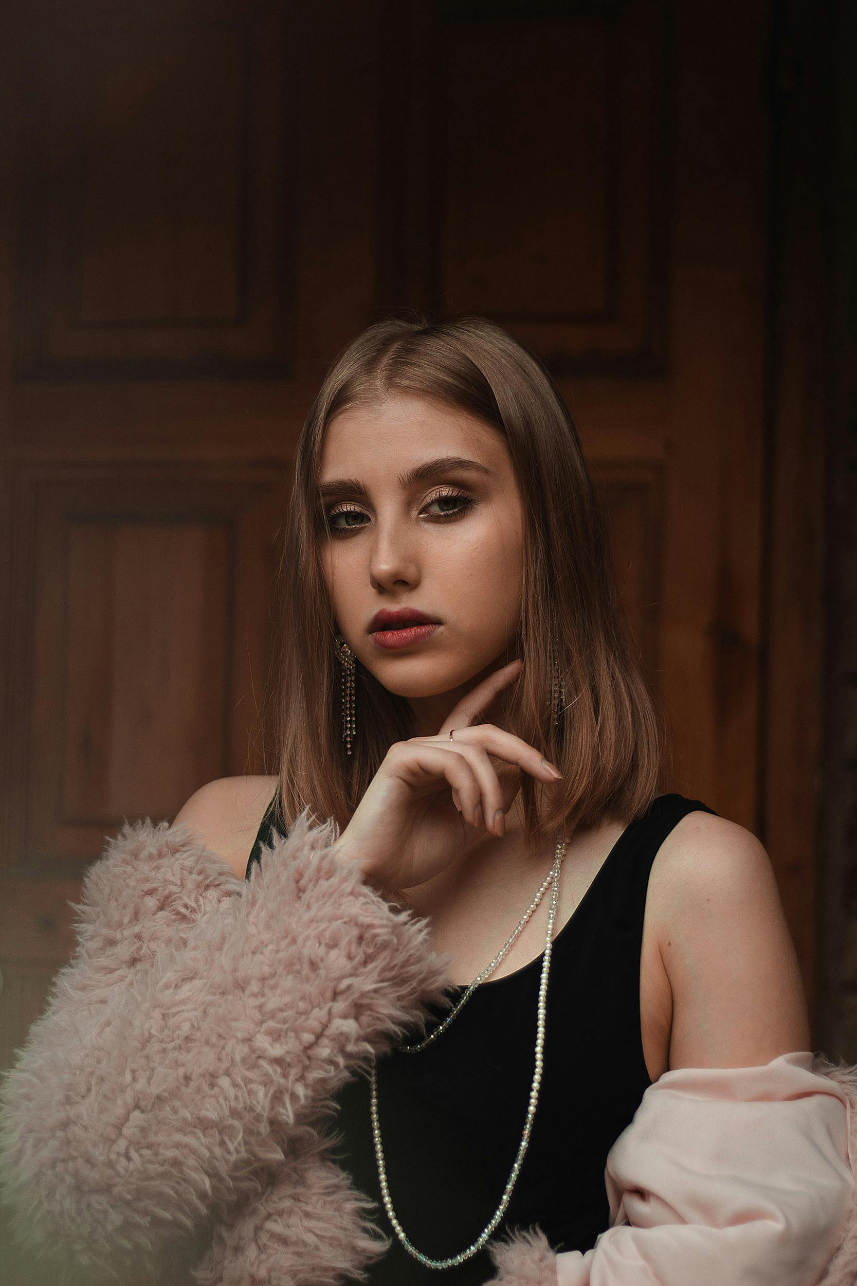 無料 毛皮のコートと宝石を身に着け、優雅さを醸し出すファッショナブルな若い女性の肖像画。 写真素材