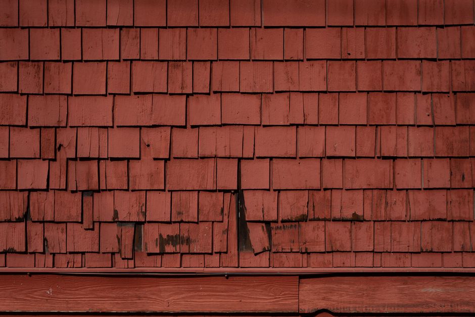 Curling shingles and granule loss in gutters indicating aged roofing material - garage repair roof Curling shingles and granule loss in gutters indicating aged roofing material - garage repair roof