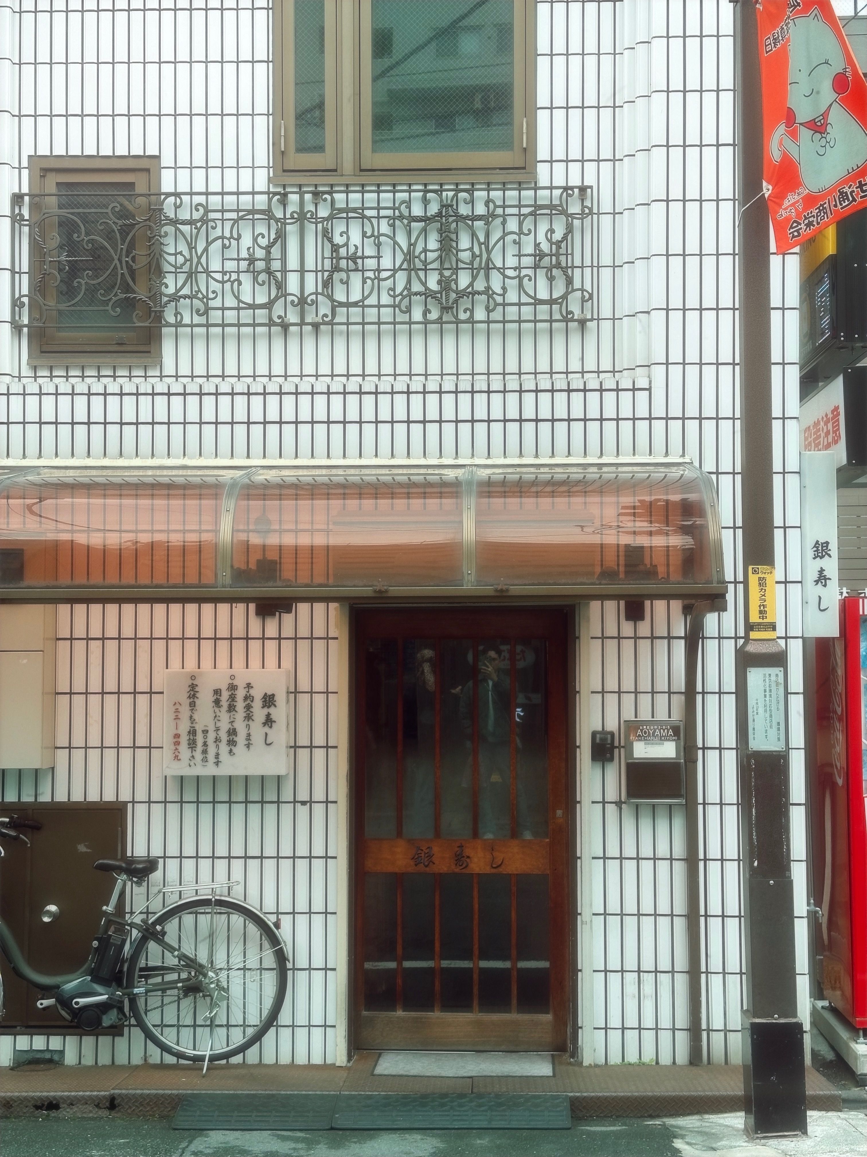 Front view of a Japanese building facade with a bicycle in urban Japan.