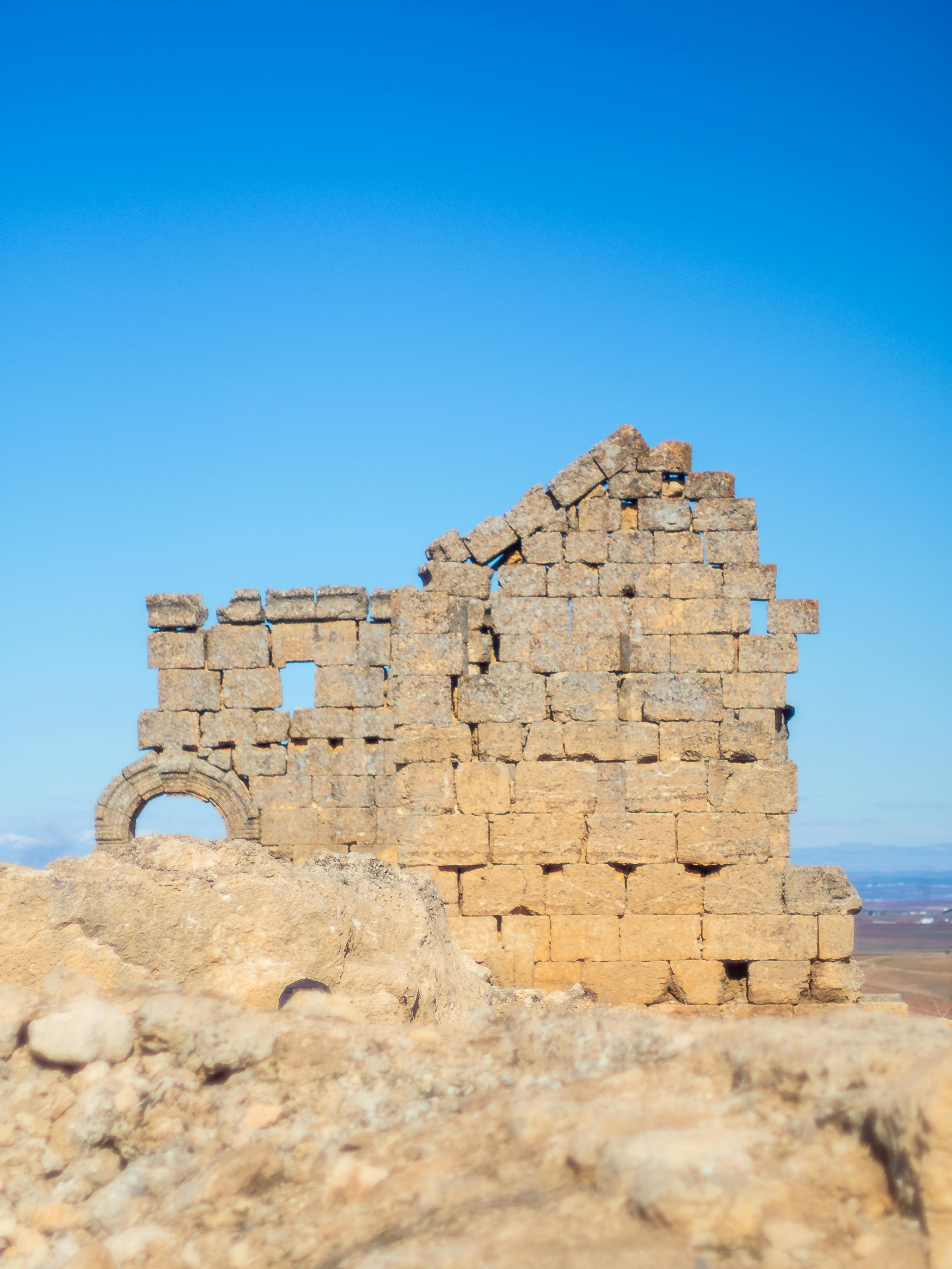 Ancient stone ruins in Diyarbakır, Türkiye, against a bright blue sky.