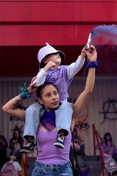 A woman carries her child on her shoulders at a Women's Day protest in Mexico City.