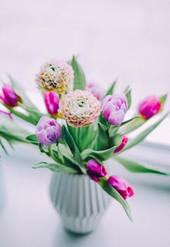 A beautiful vase of pink tulips and ranunculus creating a tranquil spring ambiance.
