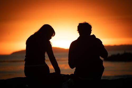 Free A captivating silhouette of a couple enjoying a seaside sunset, exuding warmth and tranquility. Stock Photo