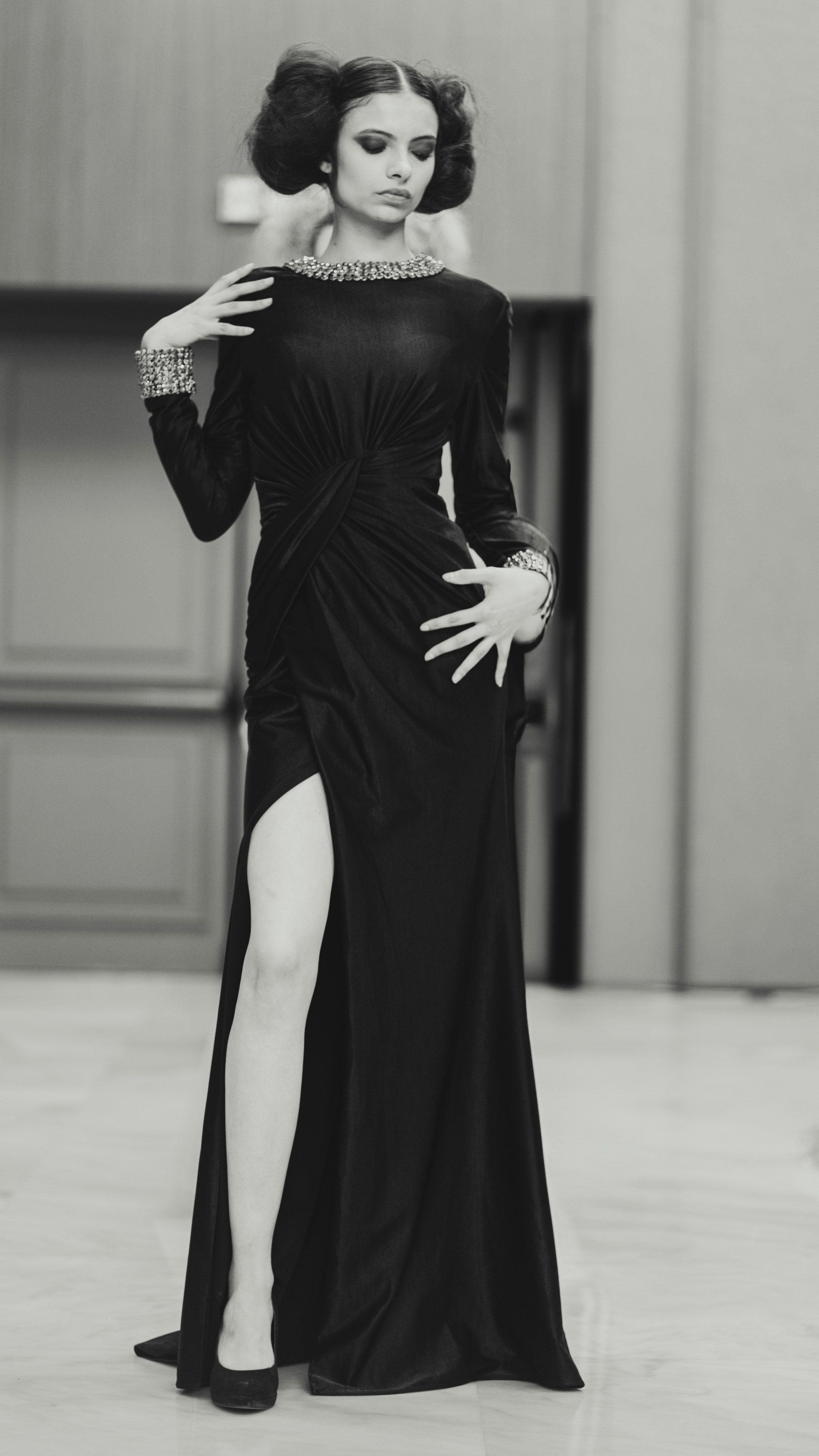 Stylish woman poses in an elegant black evening gown, showcasing modern fashion in Milan.