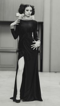 Stylish woman poses in an elegant black evening gown, showcasing modern fashion in Milan.