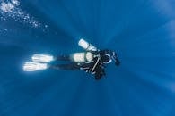 Unrecognizable diver swimming under sea water during travel
