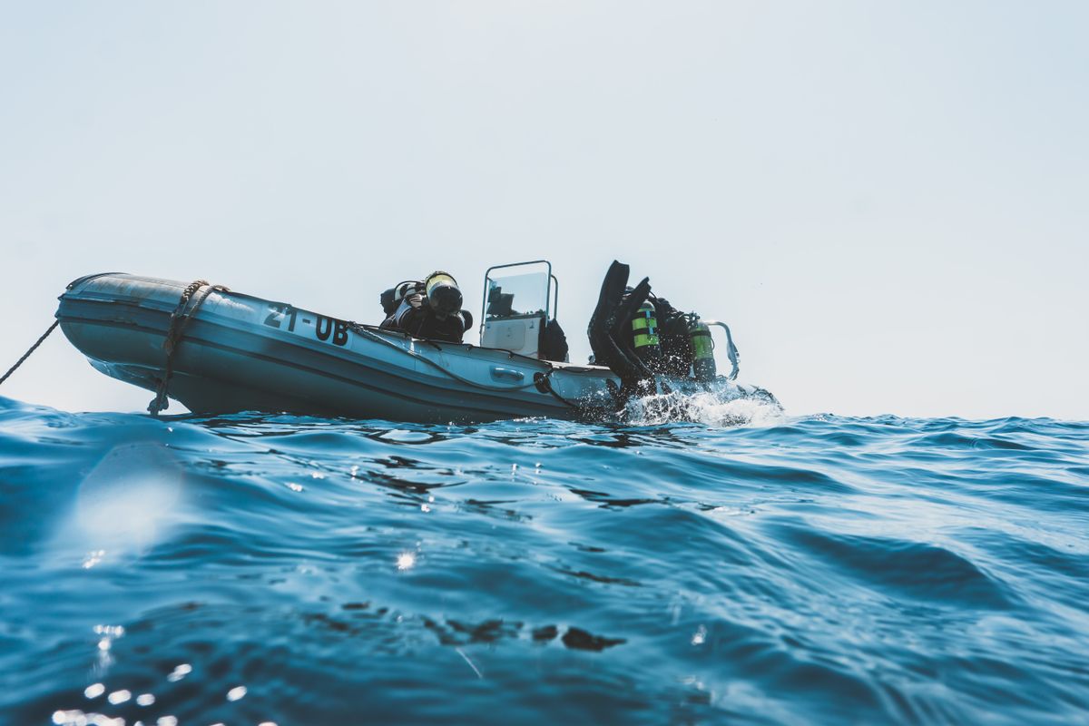 Dive travelers entering the water from a boat